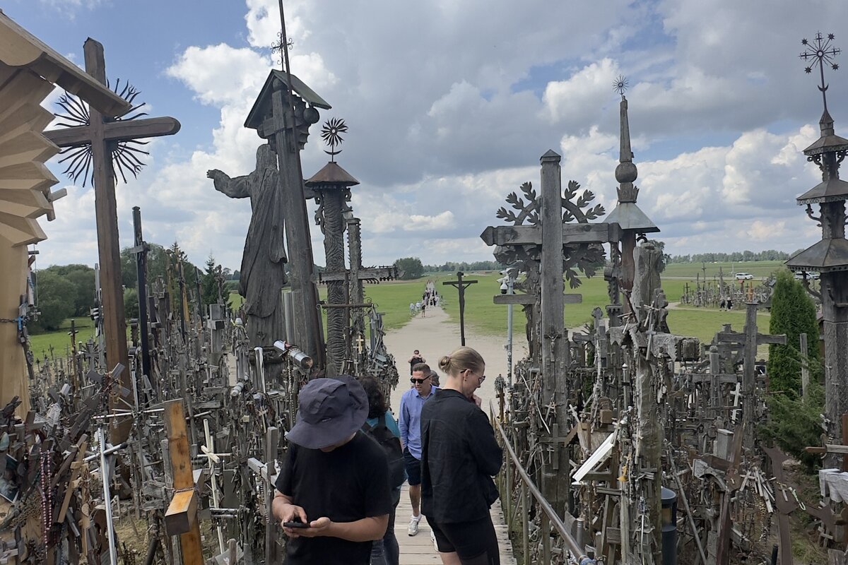 Hill of Crosses, Lithuania — boardwalk approach with the pilgrim Jesus statue and hand-carved crosses.