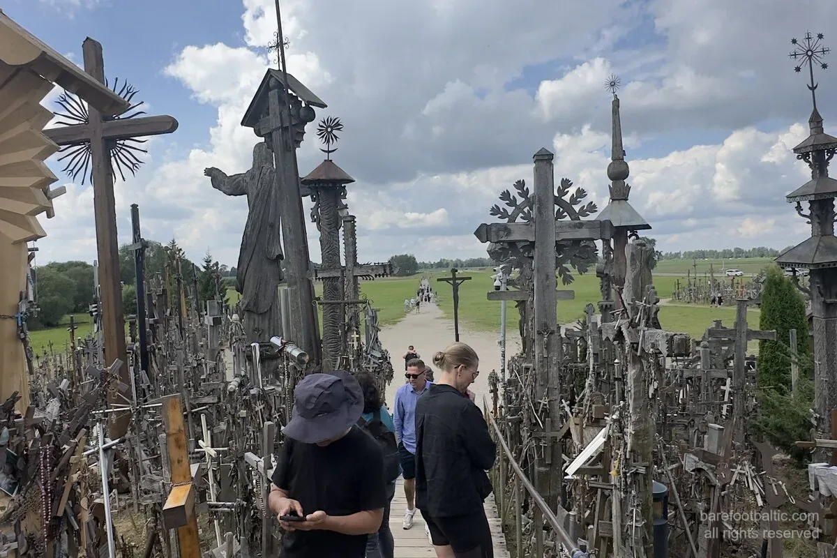 Hill of Crosses, Lithuania — boardwalk approach with the pilgrim Jesus statue and hand-carved crosses.