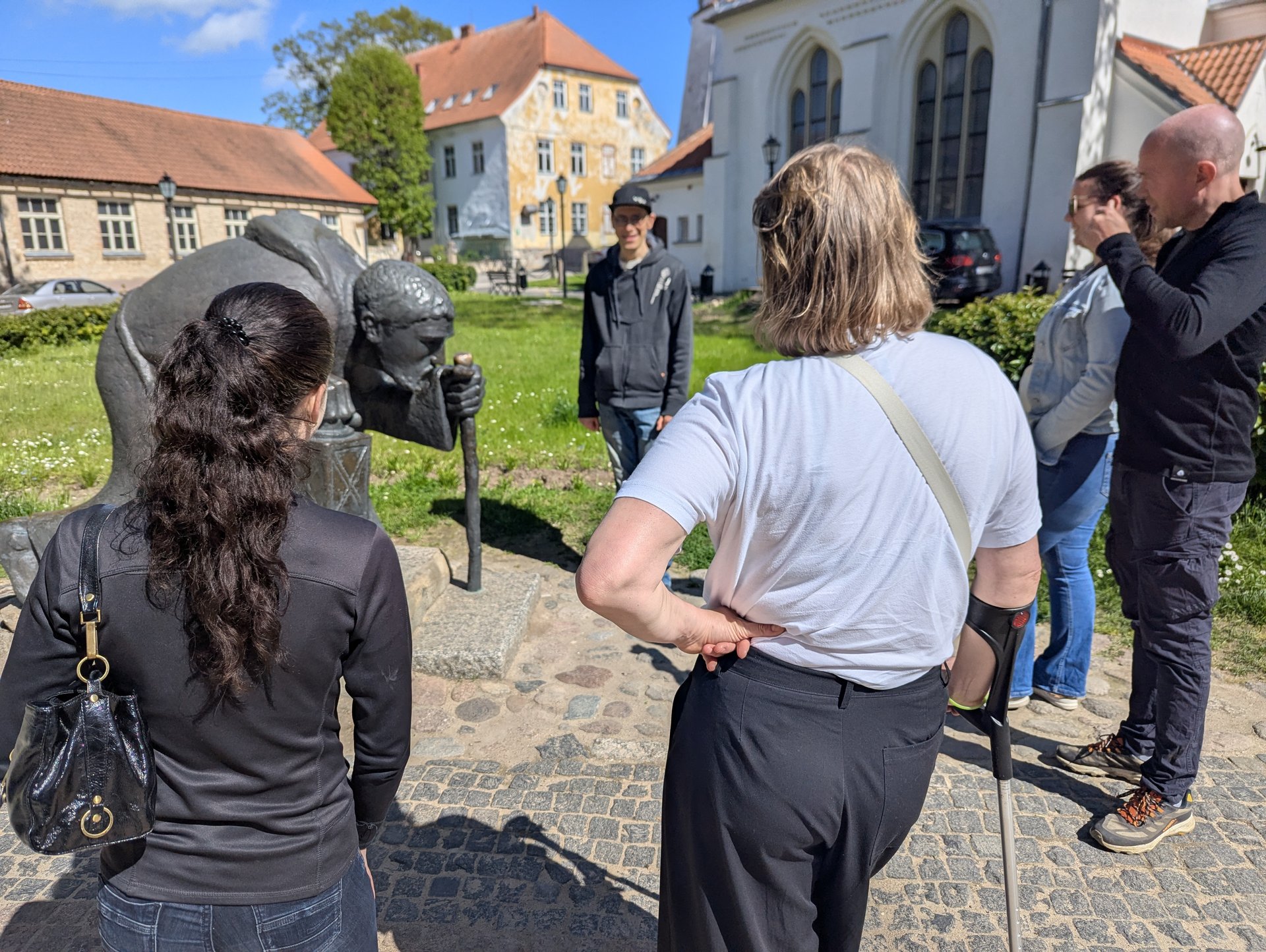 Tour group around the bronze pilgrim sculpture in Cēsis old town