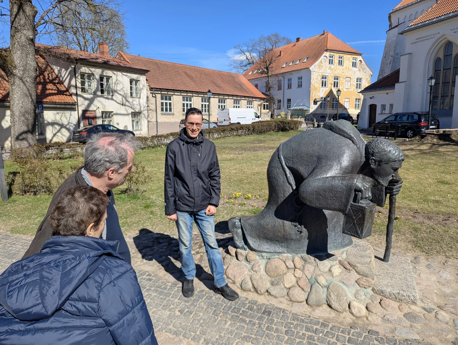 Tour group beside the bronze pilgrim sculpture in Cēsis