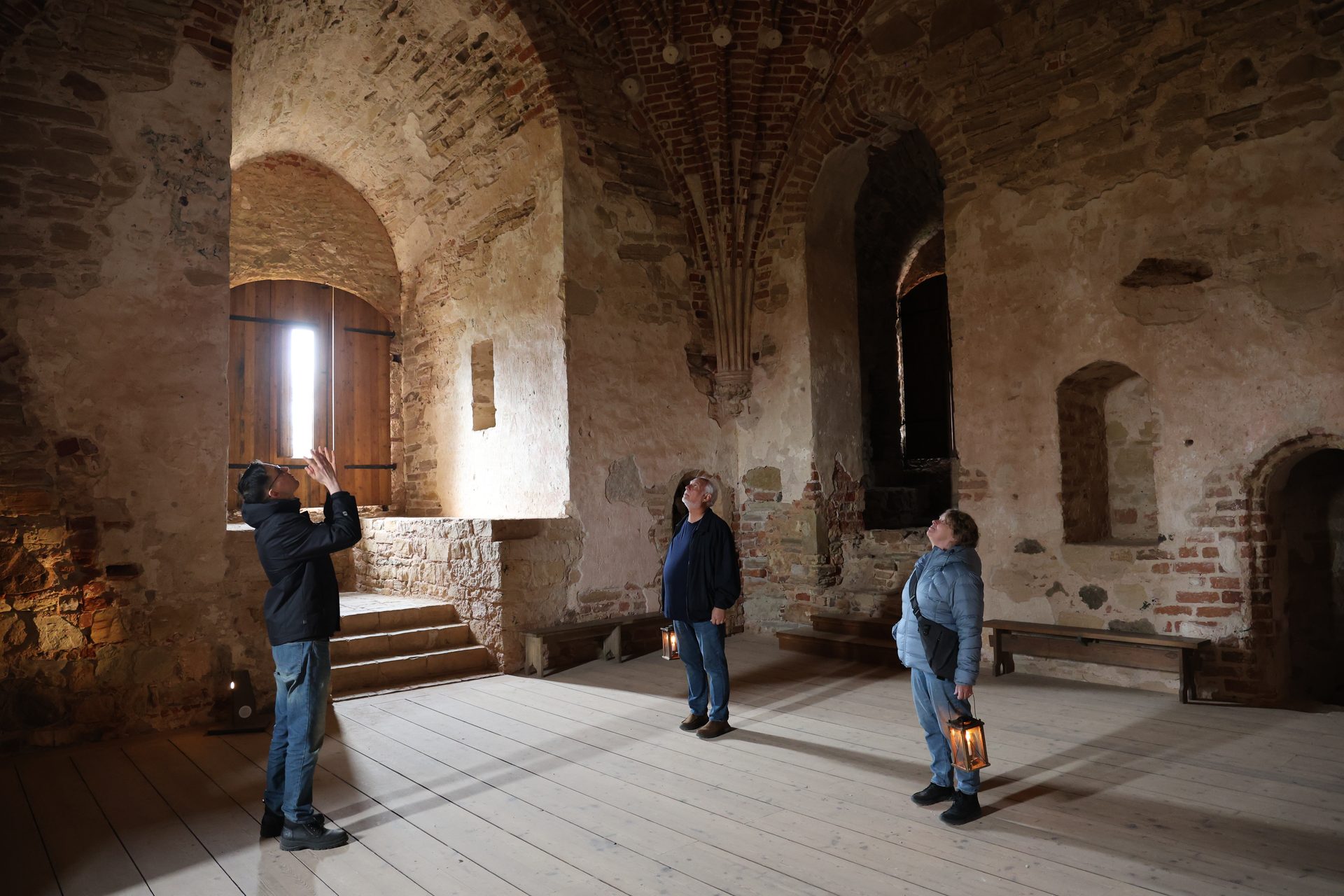 Guests with candle lanterns inside Cēsis Medieval Castle