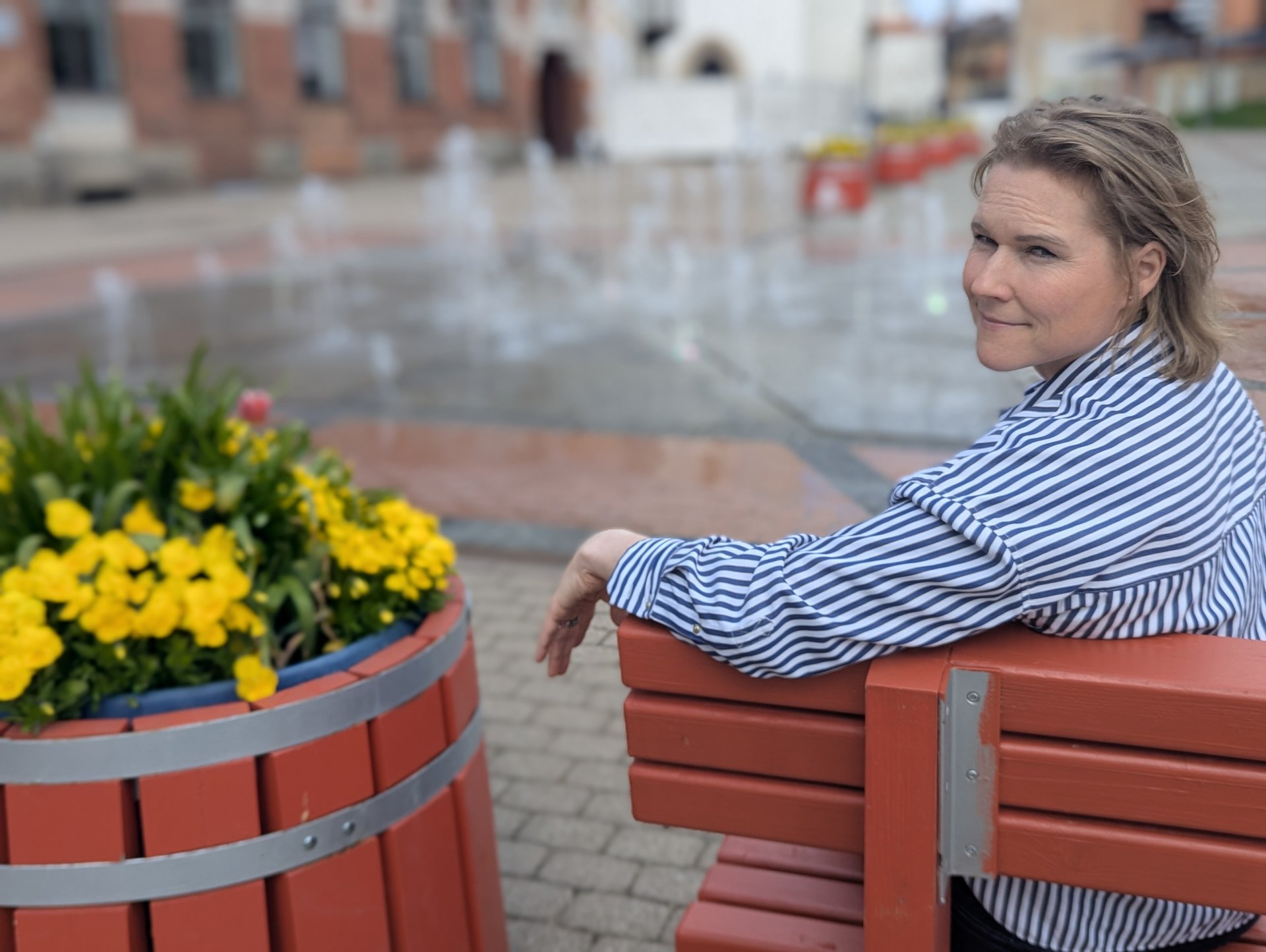 Daiga on a bench beside the fountains on Vienības laukums, Cēsis