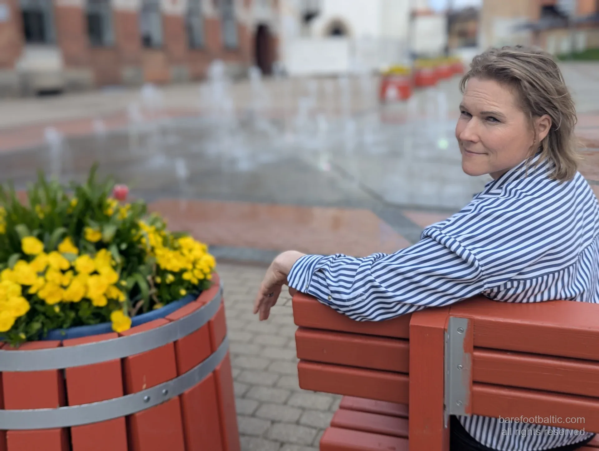 Daiga on a bench beside the fountains on Vienības laukums, Cēsis