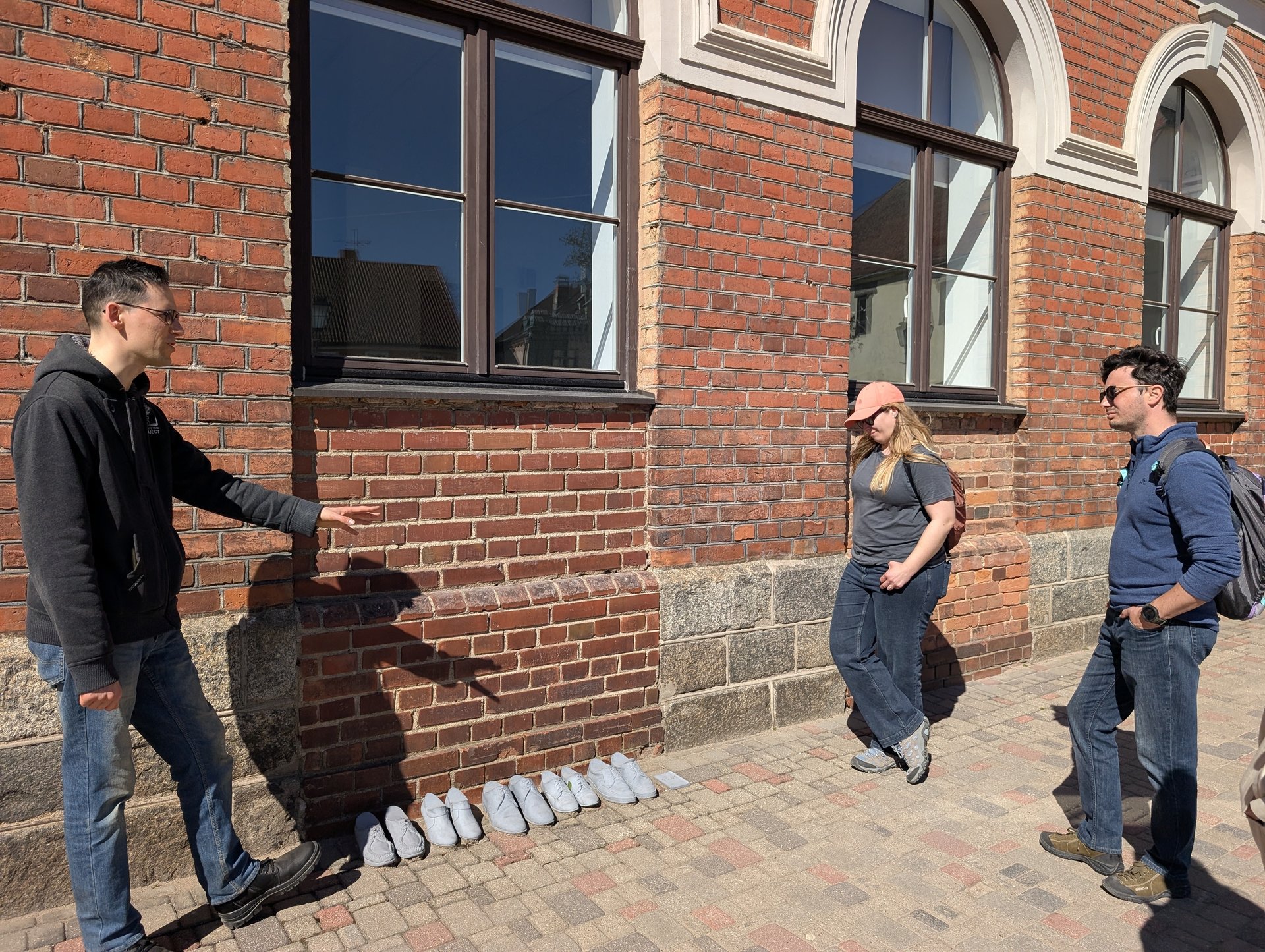 Guide pointing out wall details on the Cēsis old-town walking tour