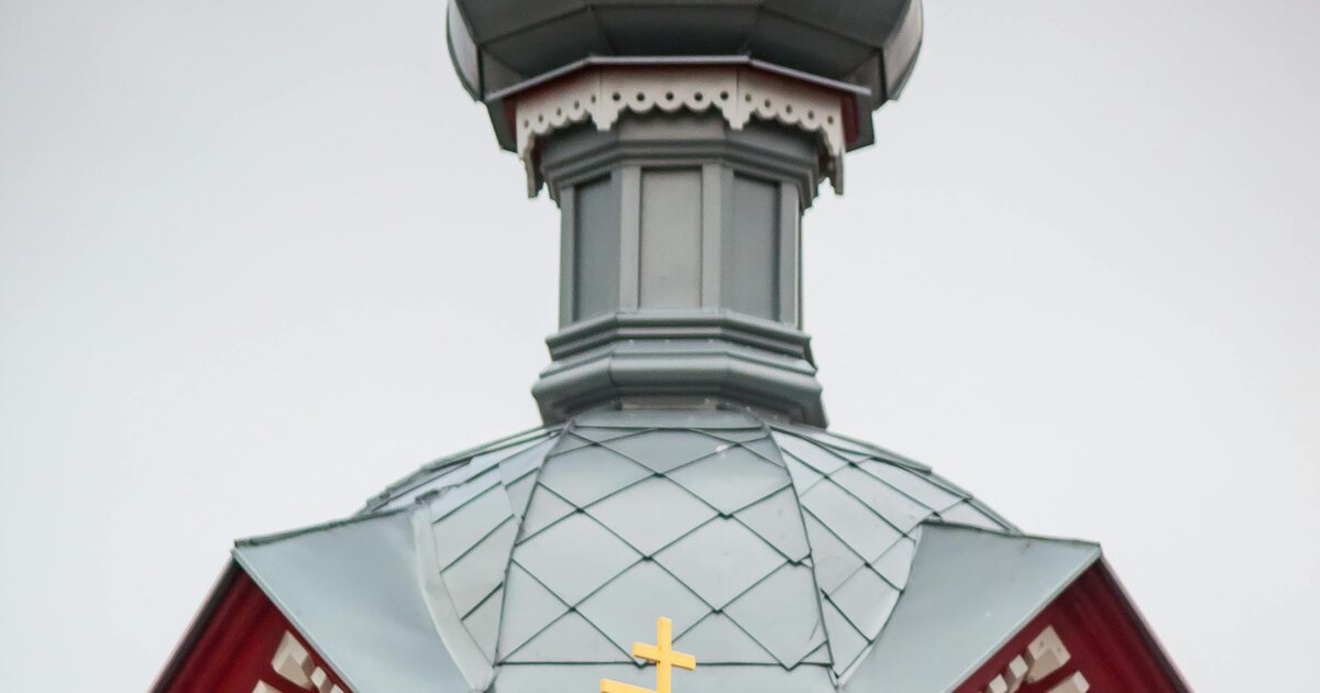 A wooden Orthodox church with onion dome and the eight-pointed three-bar Orthodox cross — Latvia.